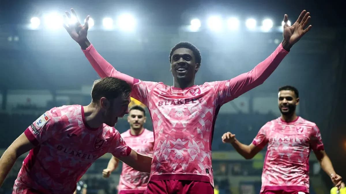 Players celebrating a goal in pink jerseys Players celebrating a goal in pink jerseys