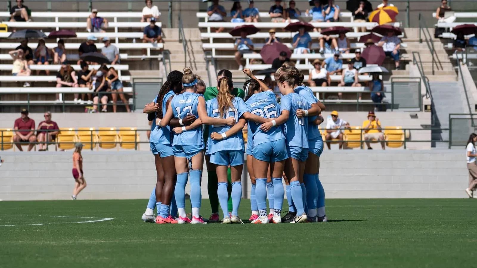 Team huddled together on the field before match Team huddled together on the field before match