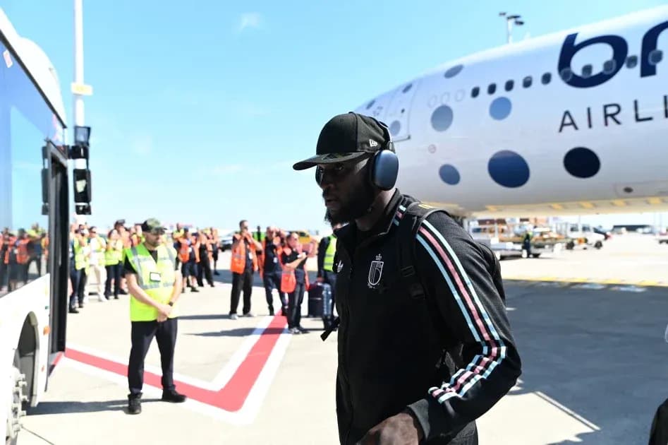Player arriving at airport near aircraft and staff Player arriving at airport near aircraft and staff