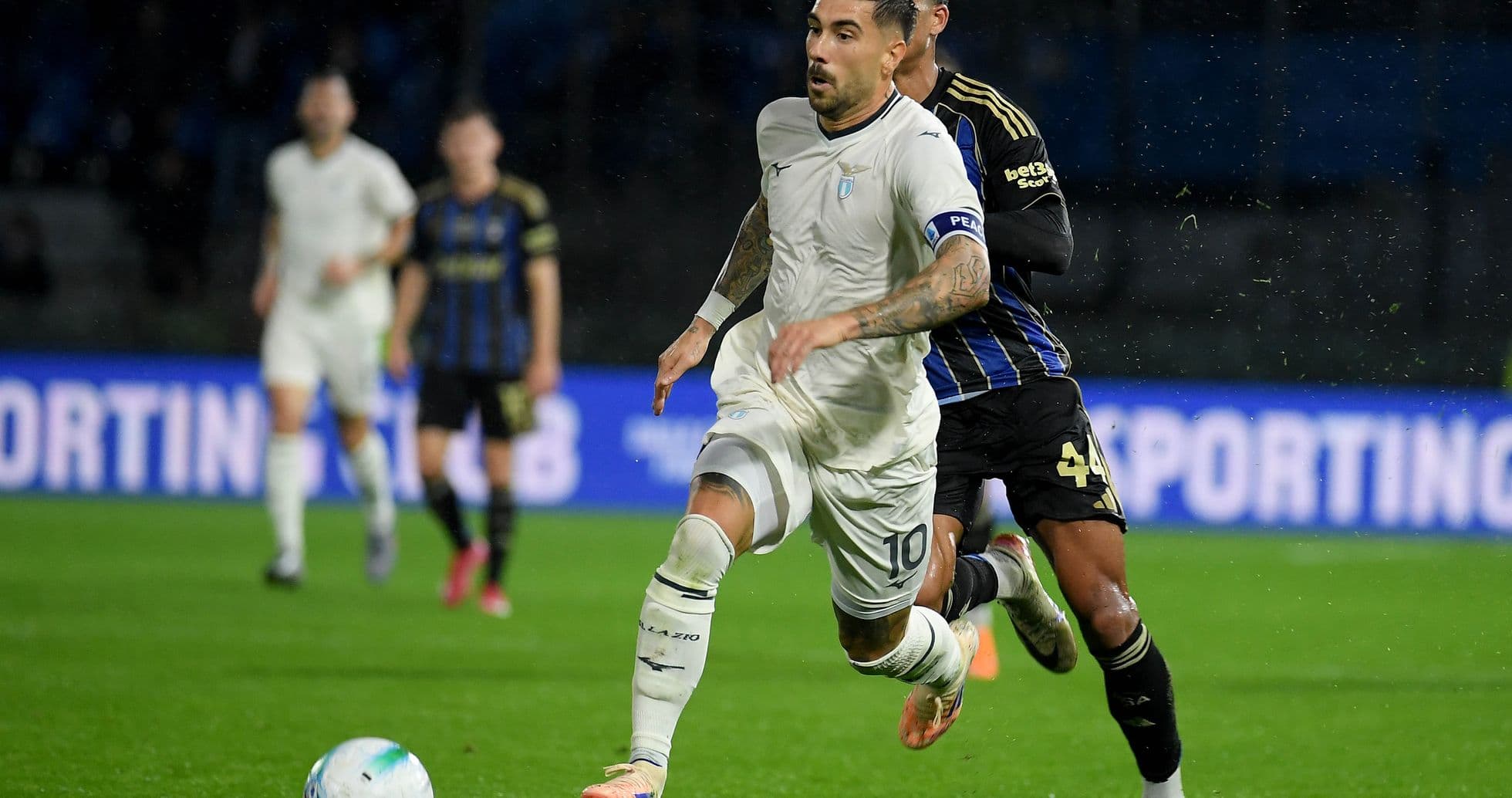 Lazio player evading Pisa defender during match Lazio player evading Pisa defender during match