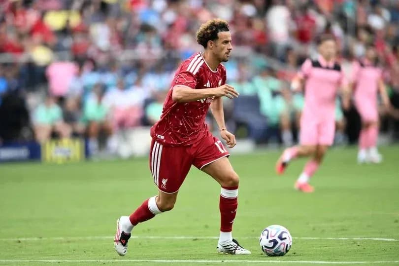 Player in red dribbling the ball on field Player in red dribbling the ball on field