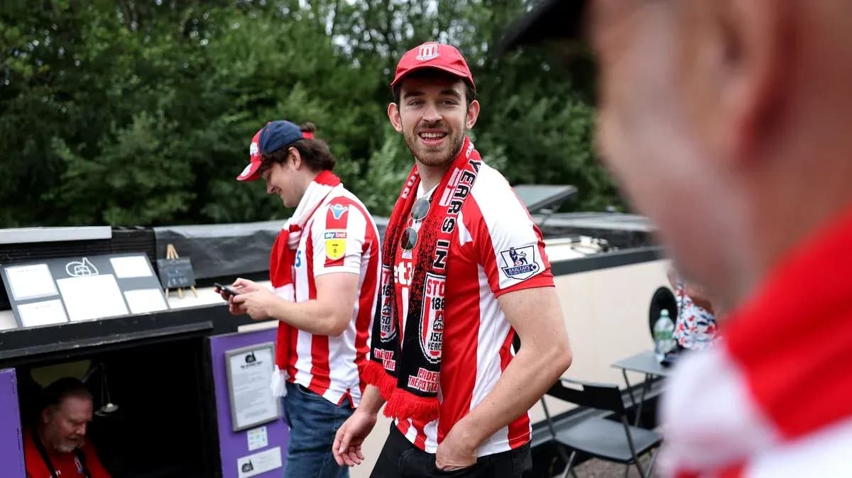 Fans wearing Stoke City shirts and scarves outdoors Fans wearing Stoke City shirts and scarves outdoors
