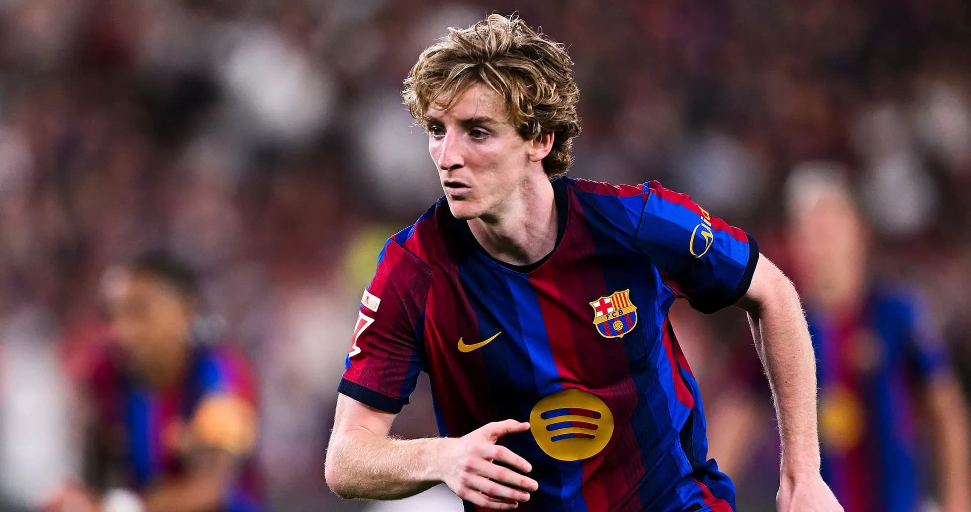 Player in FC Barcelona jersey running on the field Player in FC Barcelona jersey running on the field