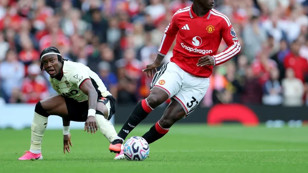 Manchester United player dribbling past opponent during match Manchester United player dribbling past opponent during match