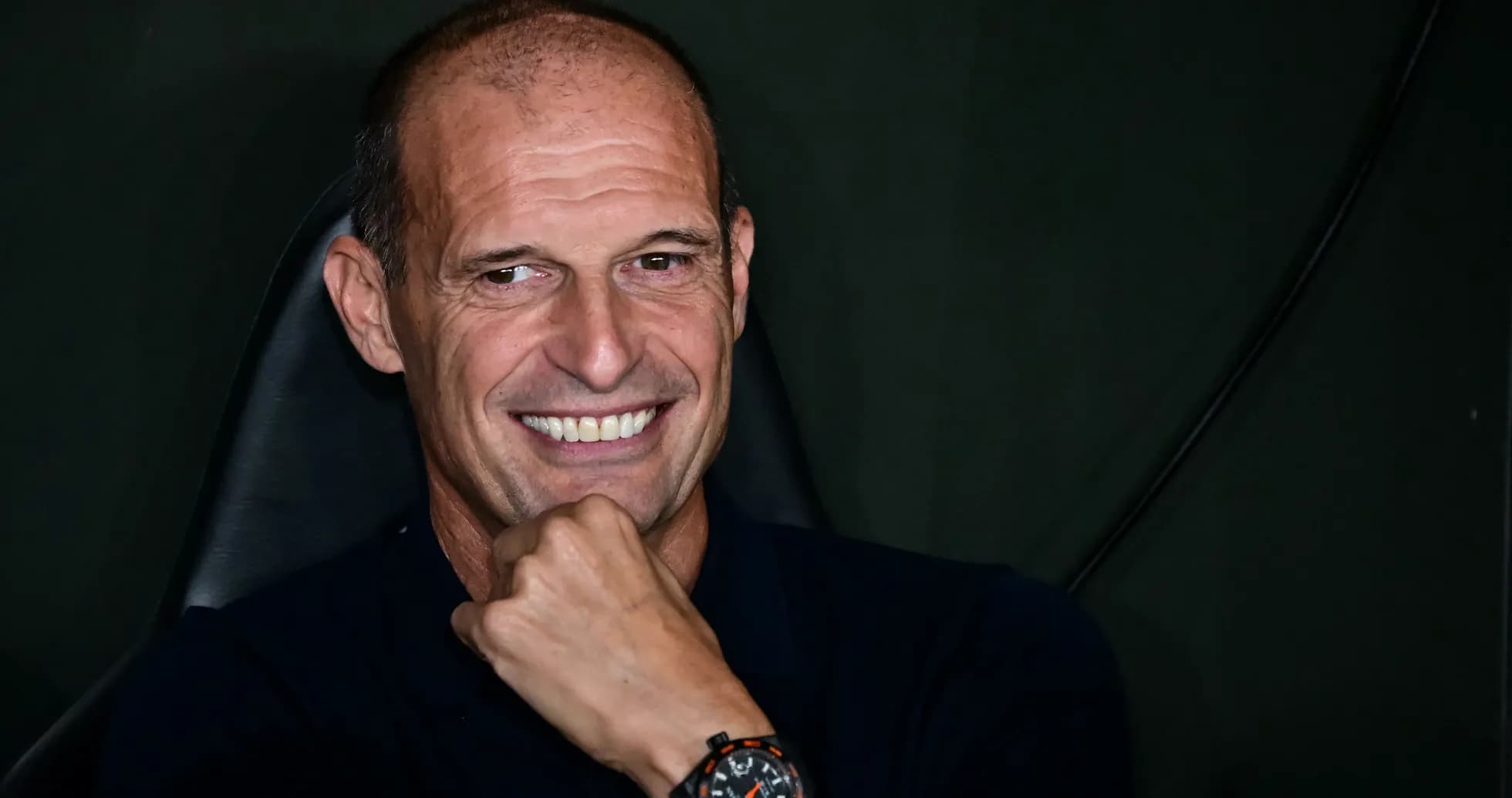 Coach smiling while seated at press conference Coach smiling while seated at press conference
