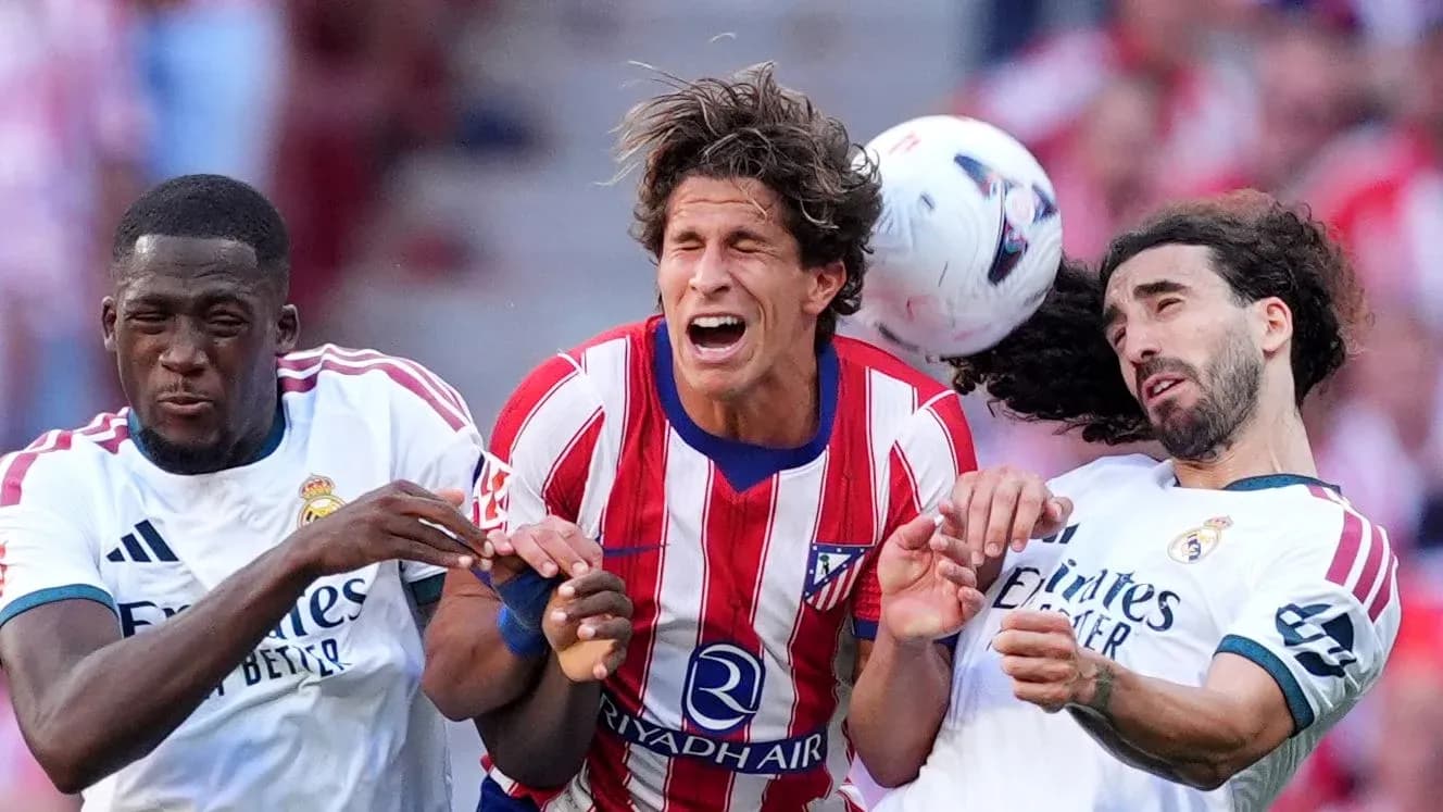 Players from Atlético and Real Madrid contesting the ball Players from Atlético and Real Madrid contesting the ball