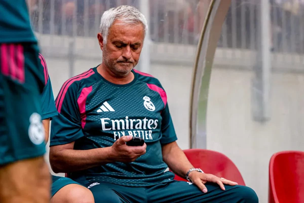 Coach seated on bench using mobile phone Coach seated on bench using mobile phone