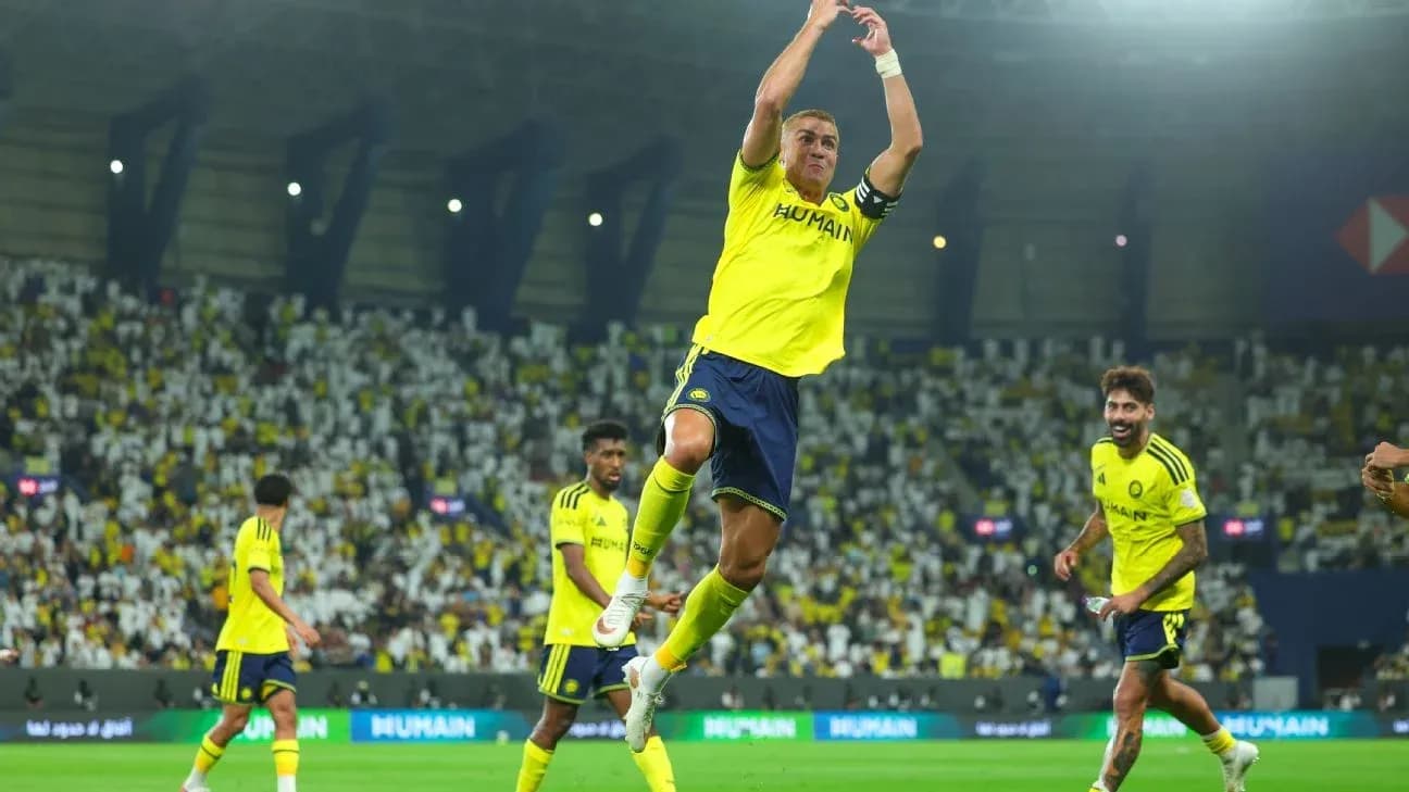Player celebrating a goal with teammates in stadium Player celebrating a goal with teammates in stadium
