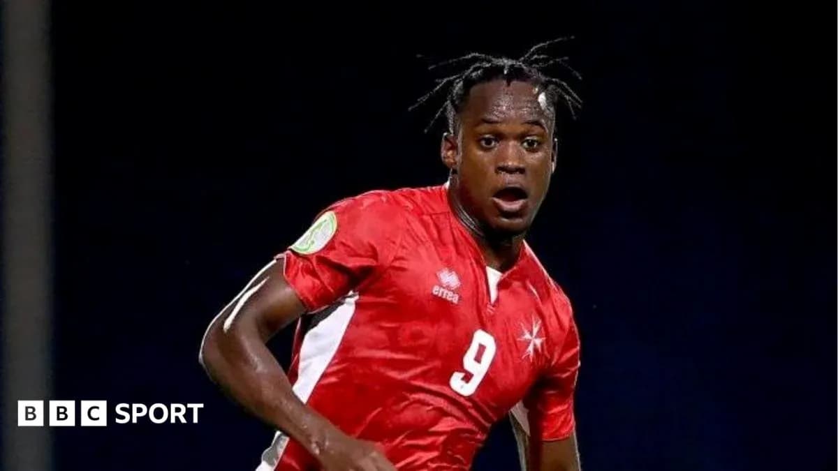Player in red jersey running during football match Player in red jersey running during football match