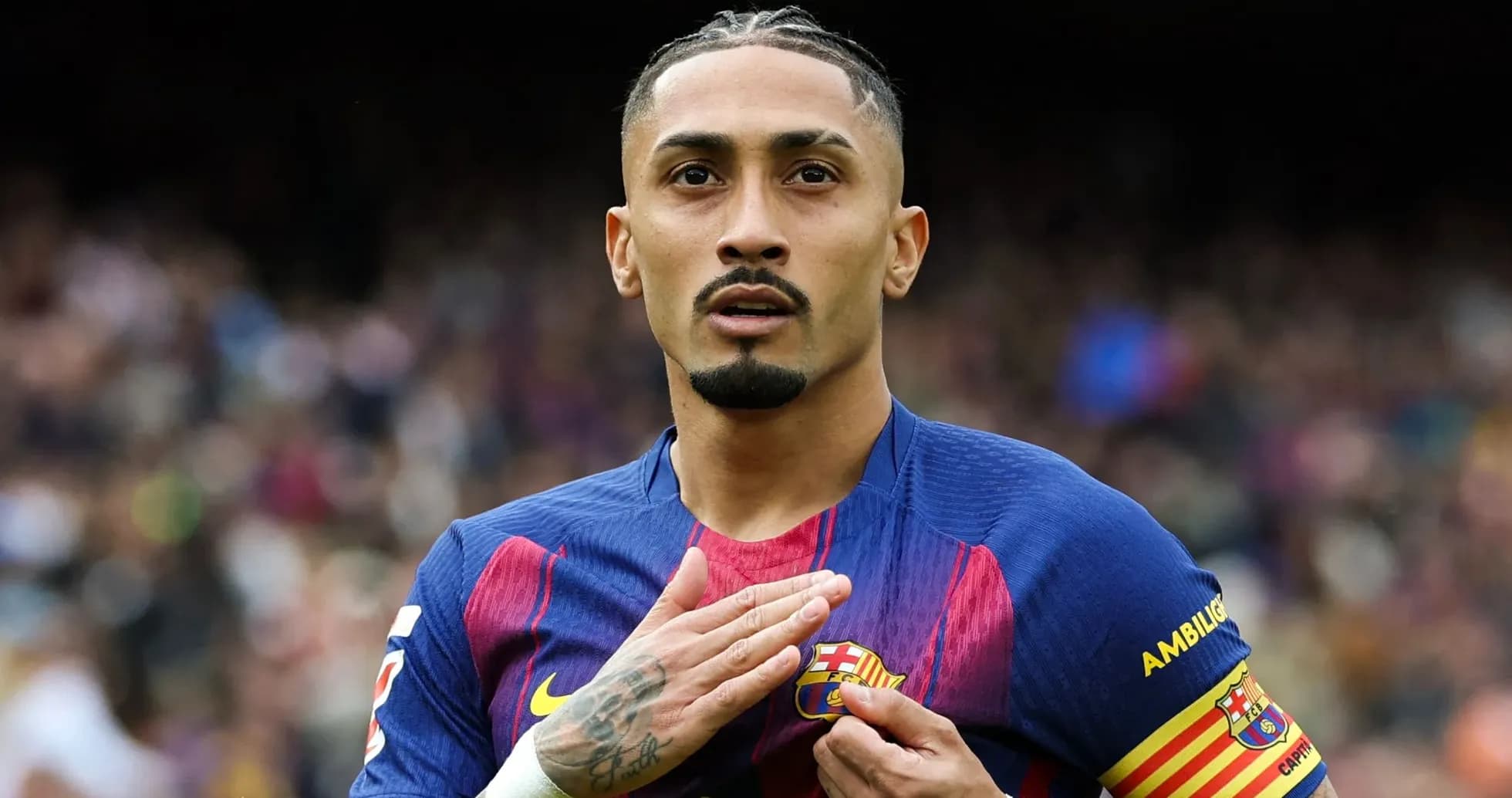 Player gesturing towards FC Barcelona badge on jersey Player gesturing towards FC Barcelona badge on jersey