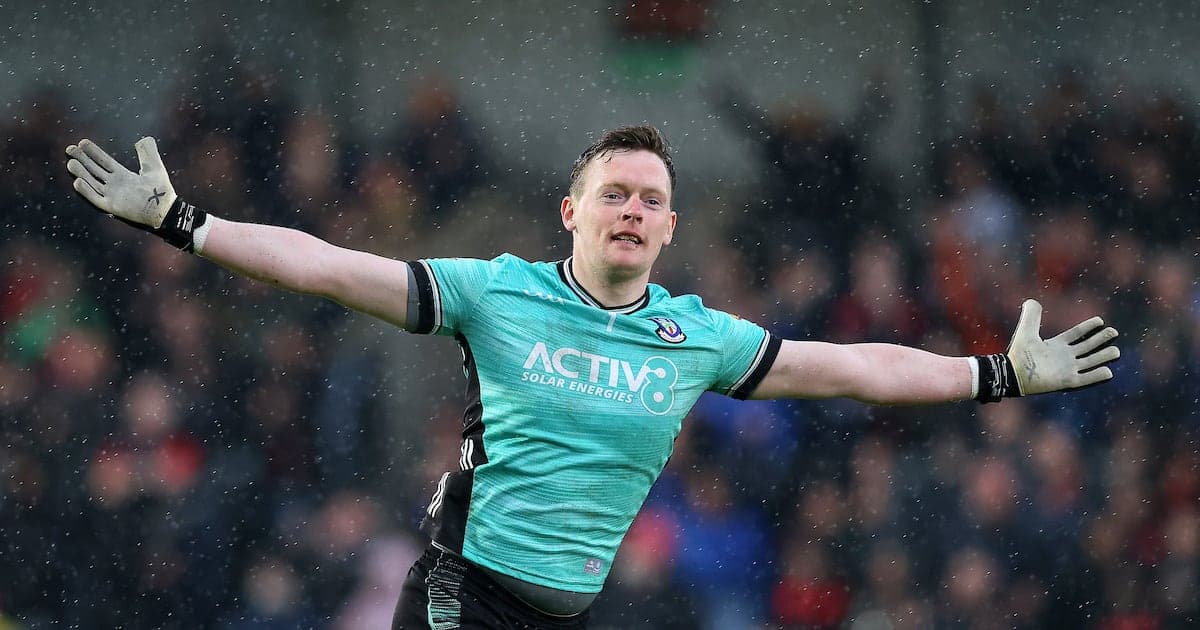 Goalkeeper celebrating with arms outstretched in rain Goalkeeper celebrating with arms outstretched in rain
