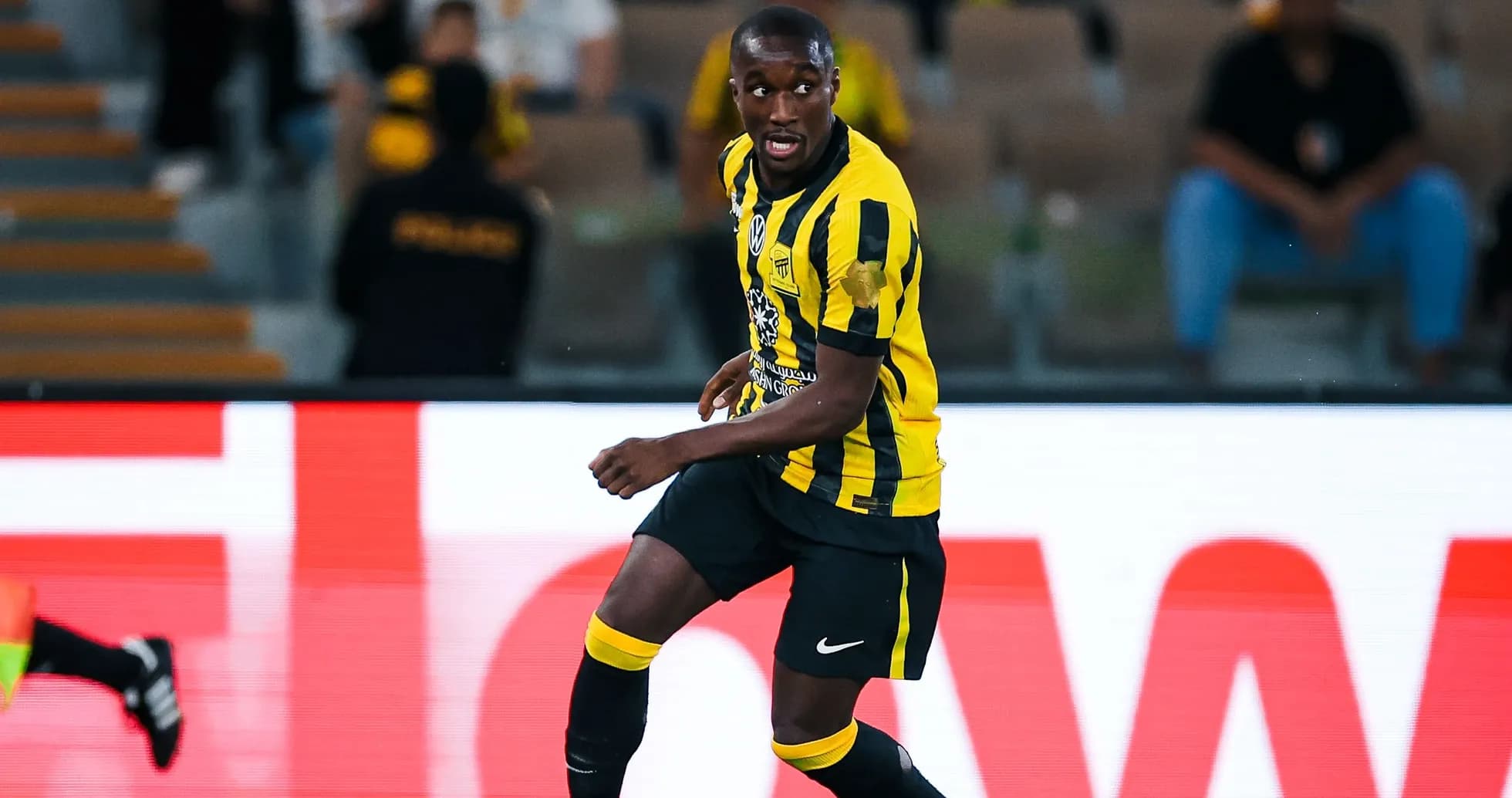 Player in yellow and black uniform during match Player in yellow and black uniform during match