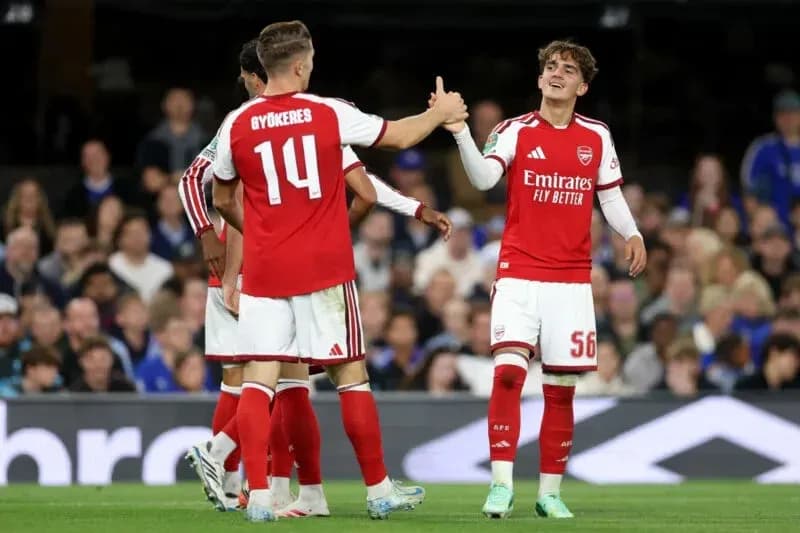 Two Arsenal players celebrating during a match Two Arsenal players celebrating during a match