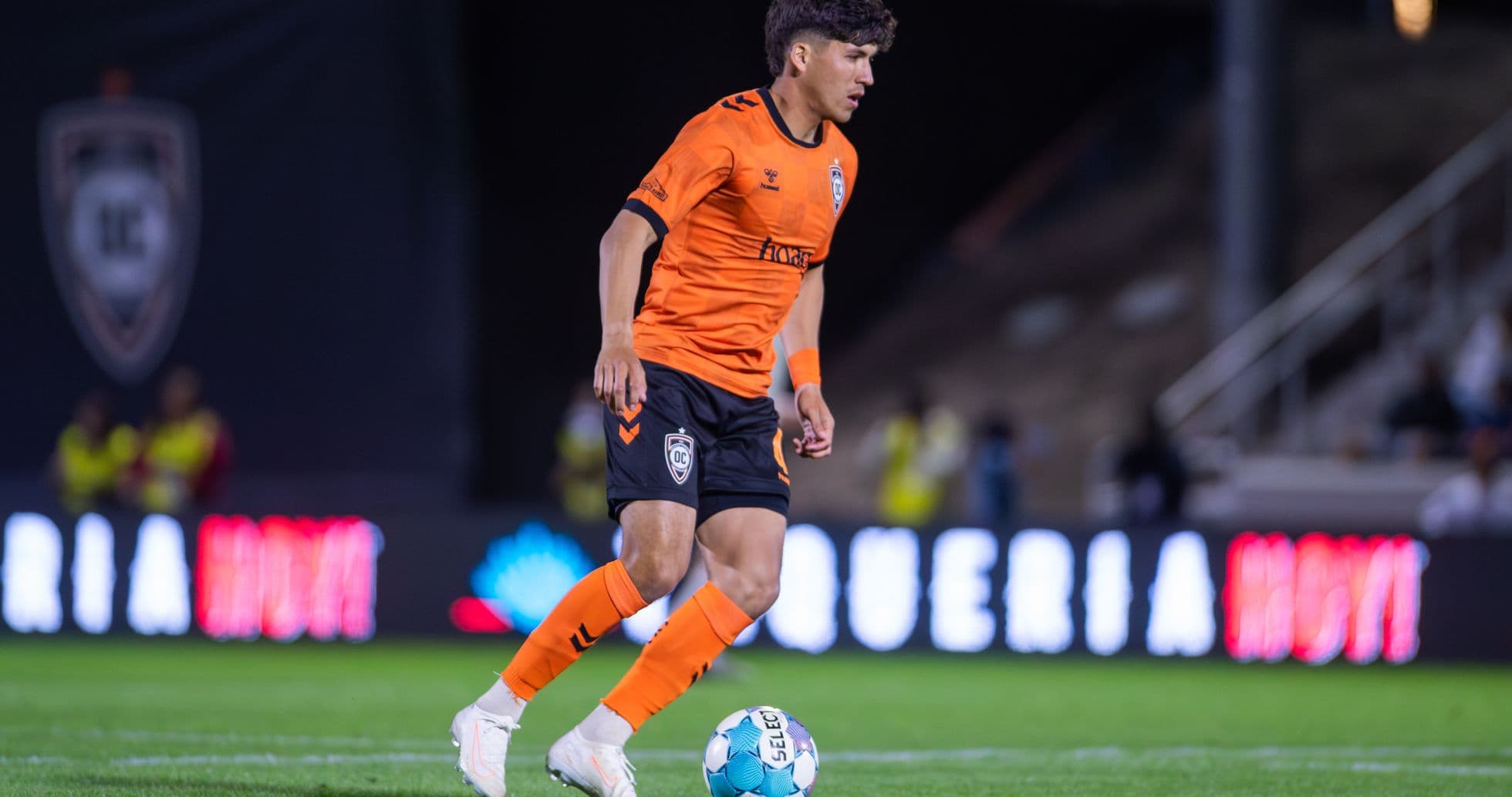 Orange County SC player dribbling ball on field Orange County SC player dribbling ball on field