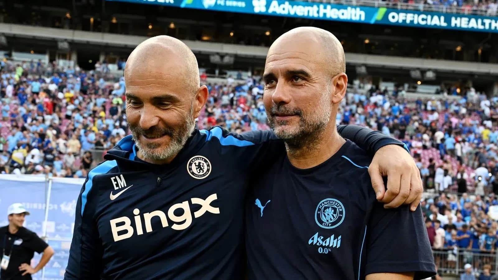 Two football managers smiling together on the field Two football managers smiling together on the field
