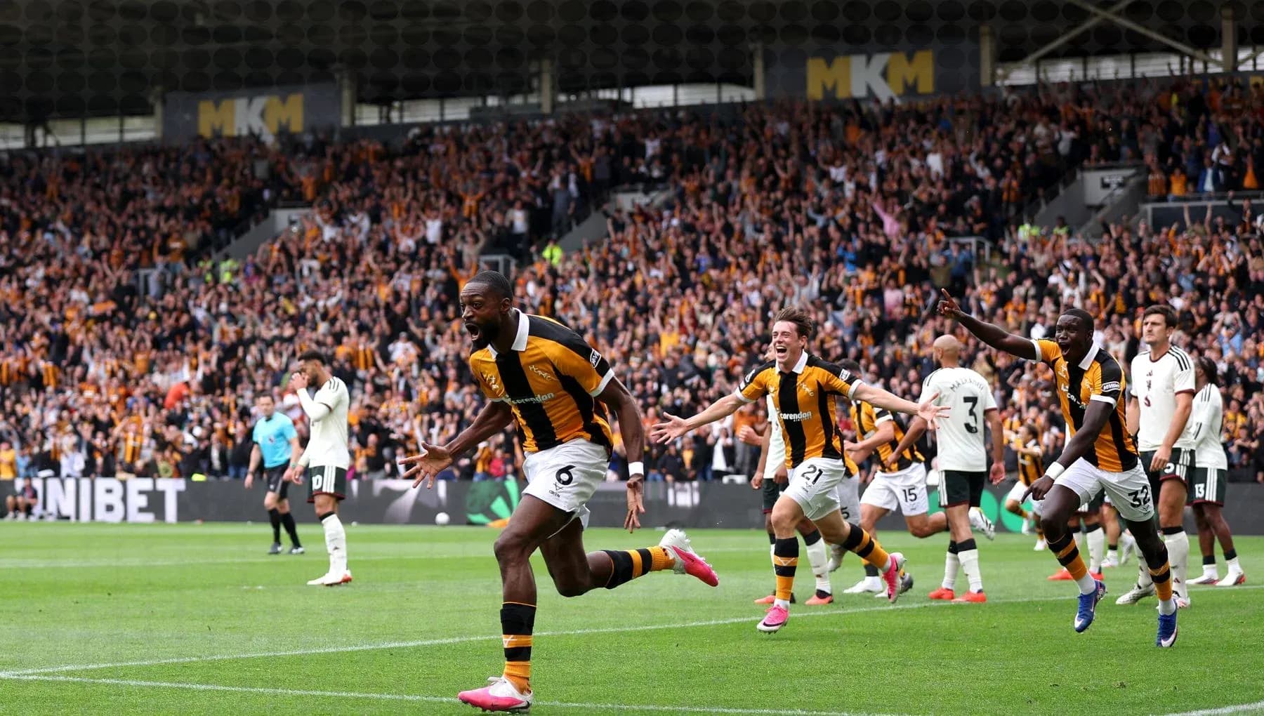Player celebrating a goal with teammates in stadium Player celebrating a goal with teammates in stadium