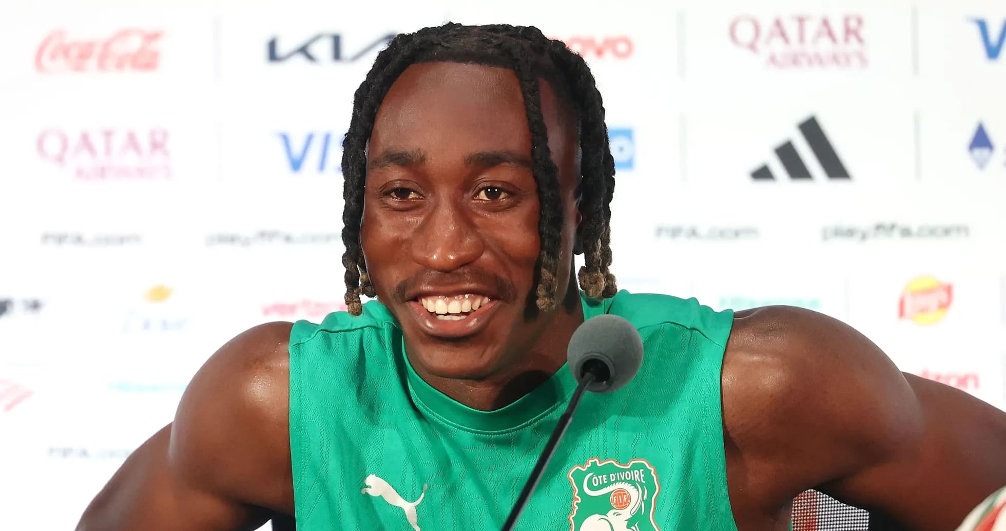 Player speaking at press conference wearing green jersey Player speaking at press conference wearing green jersey