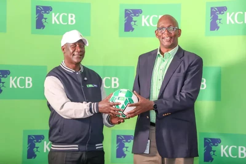 Two men holding a football at KCB event Two men holding a football at KCB event