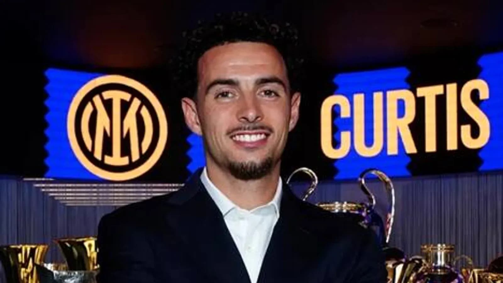 Player posing with trophies and Inter Milan logo Player posing with trophies and Inter Milan logo