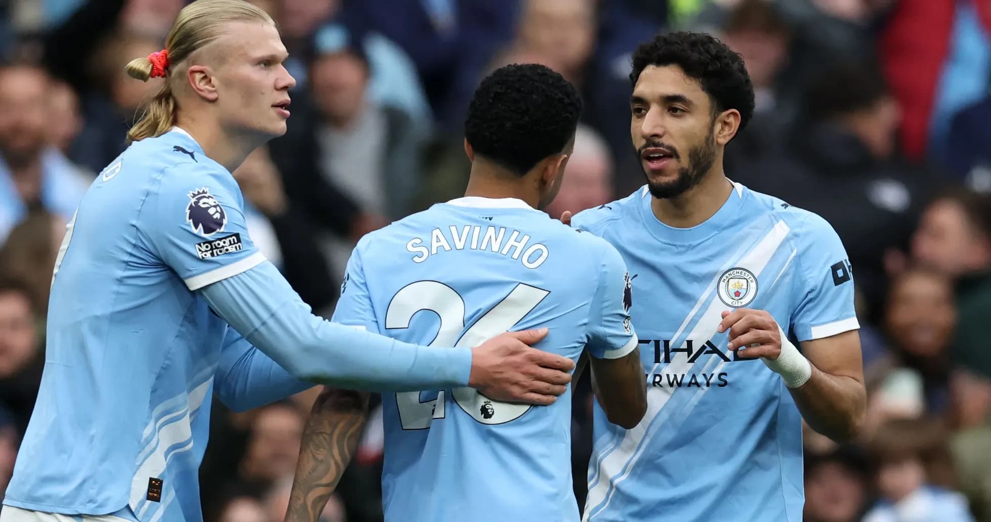 Three Manchester City players celebrating on the pitch Three Manchester City players celebrating on the pitch