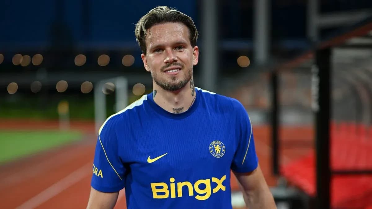 Player in blue Chelsea kit smiling on field Player in blue Chelsea kit smiling on field