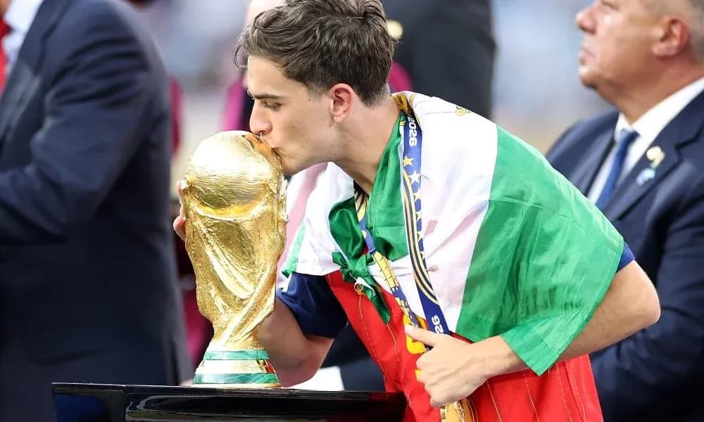 Player kissing World Cup trophy while wearing flag Player kissing World Cup trophy while wearing flag