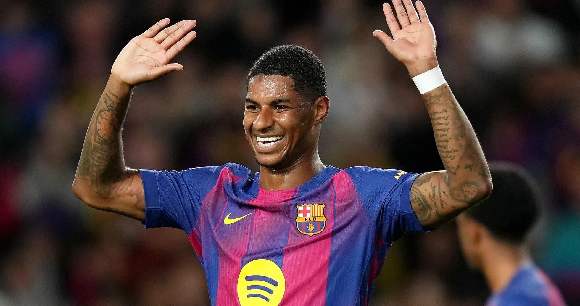 Player celebrating with arms raised on pitch Player celebrating with arms raised on pitch