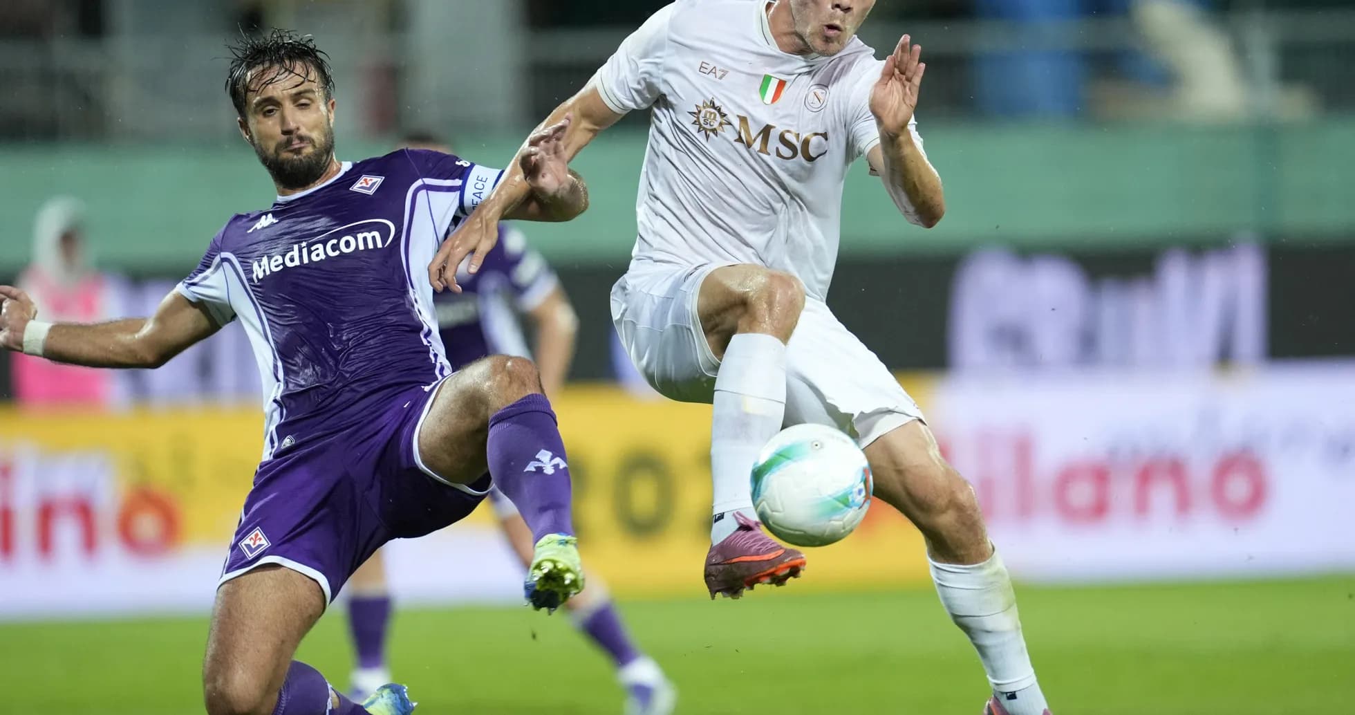 Fiorentina player tackling Napoli opponent Fiorentina player tackling Napoli opponent