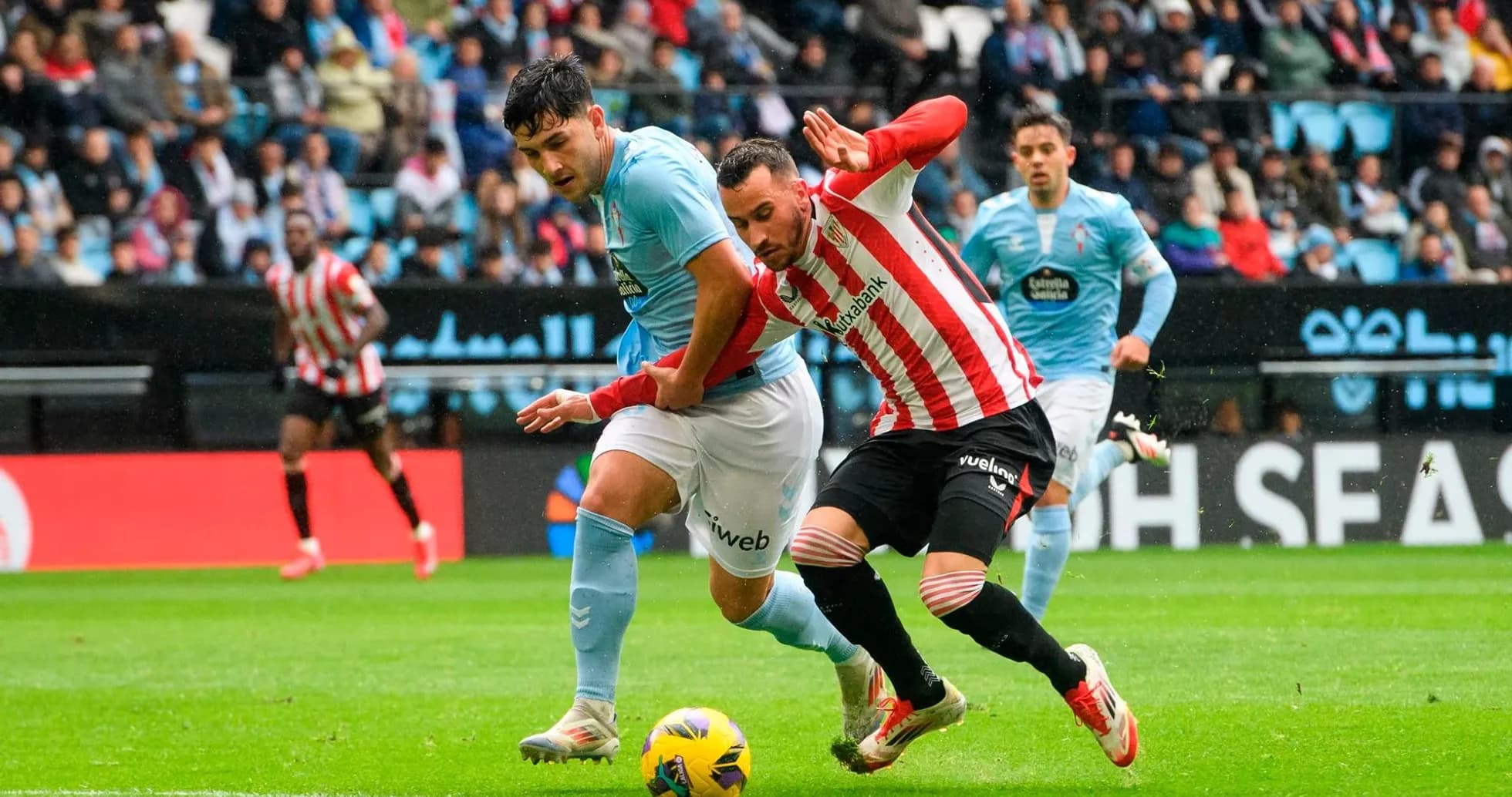Athletic Club player challenging Celta Vigo opponent Athletic Club player challenging Celta Vigo opponent