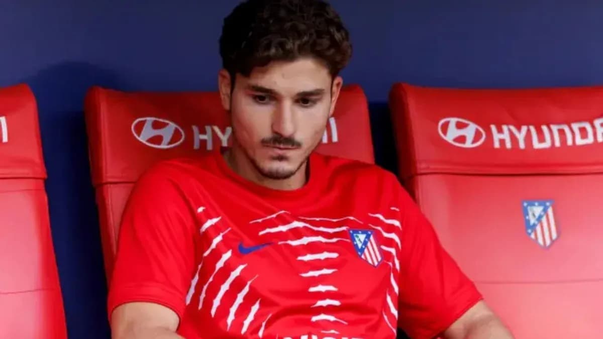 Player seated on bench wearing Atlético Madrid jersey Player seated on bench wearing Atlético Madrid jersey