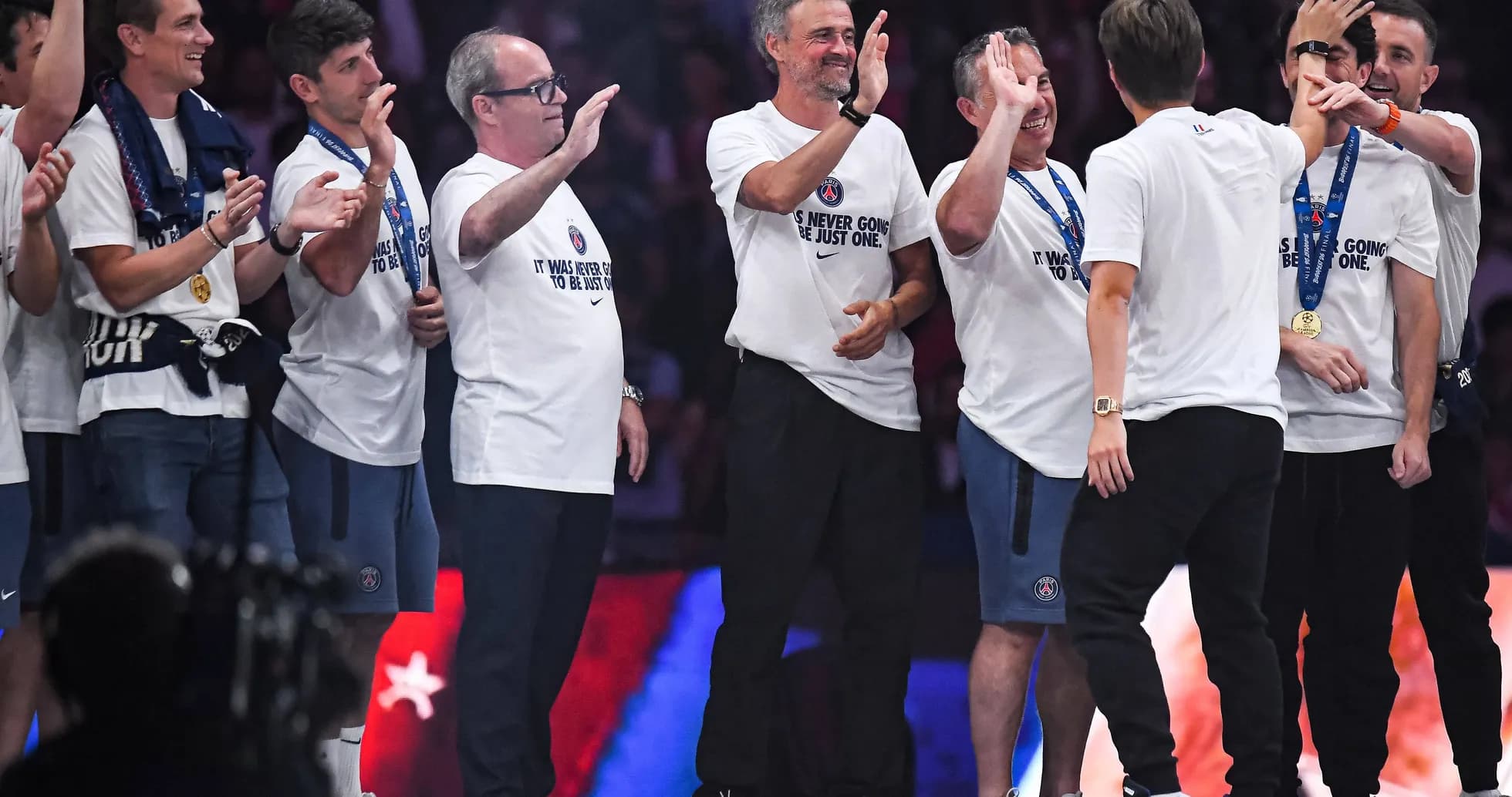 Coaching staff celebrating with team members on stage Coaching staff celebrating with team members on stage