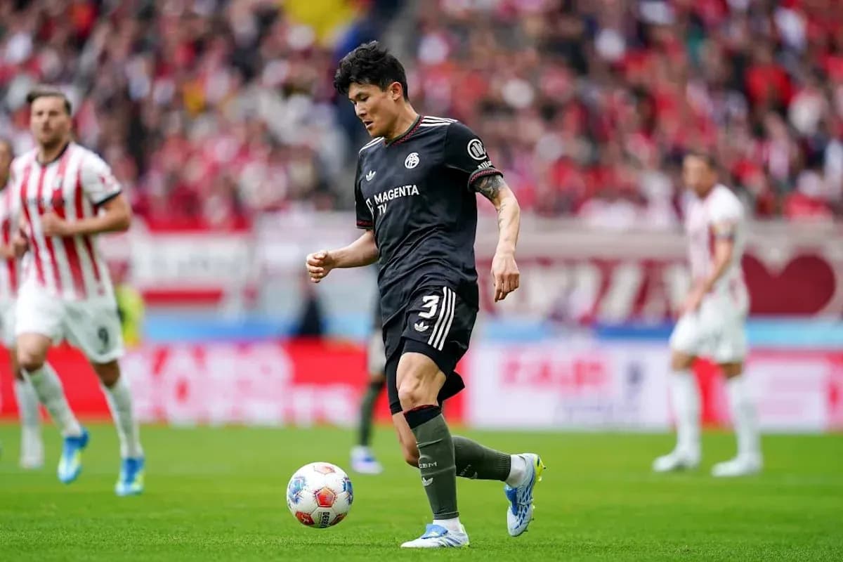 Player in black uniform dribbling the ball on field Player in black uniform dribbling the ball on field