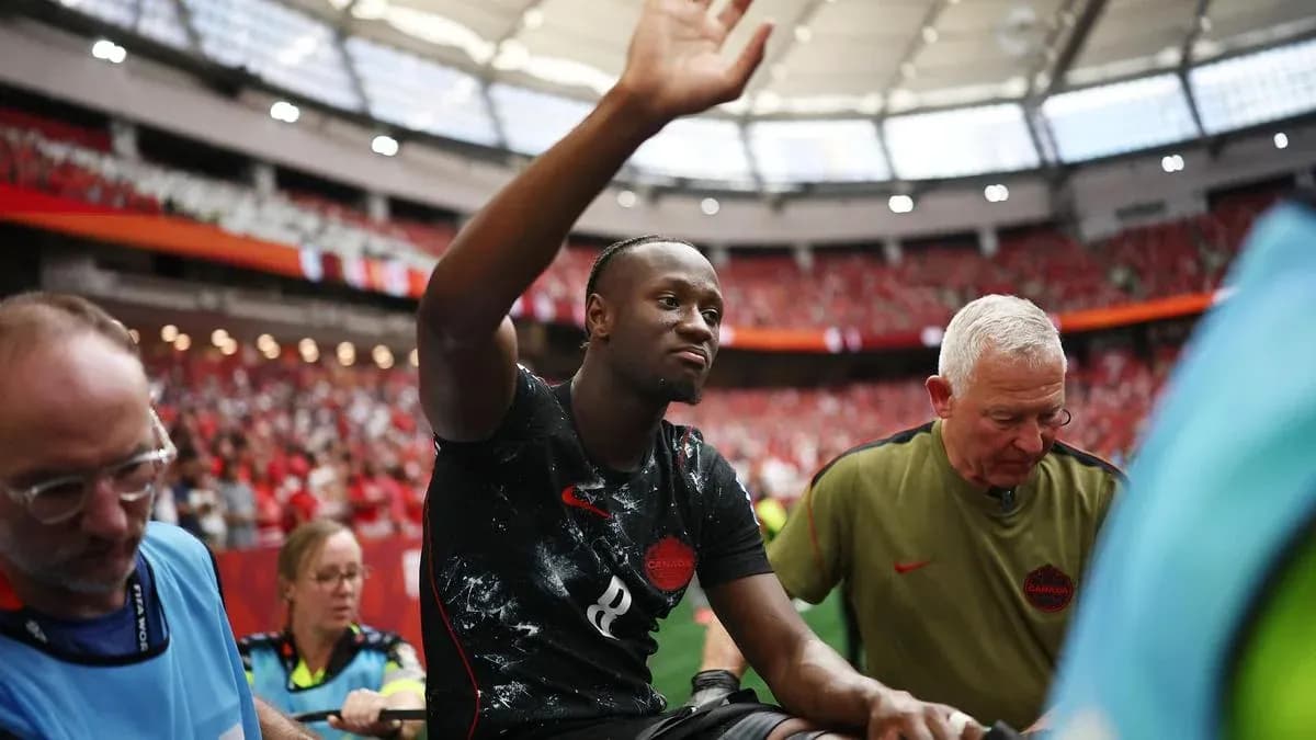 Player waving while being assisted off the field Player waving while being assisted off the field