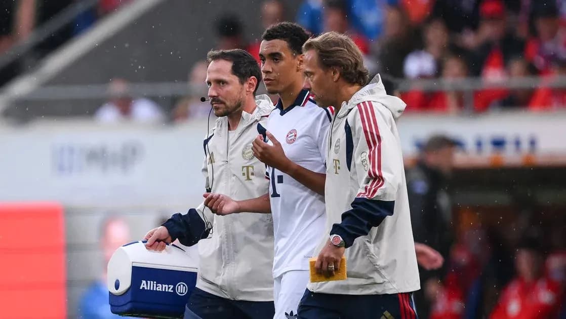 Player receiving medical attention from staff on sideline Player receiving medical attention from staff on sideline