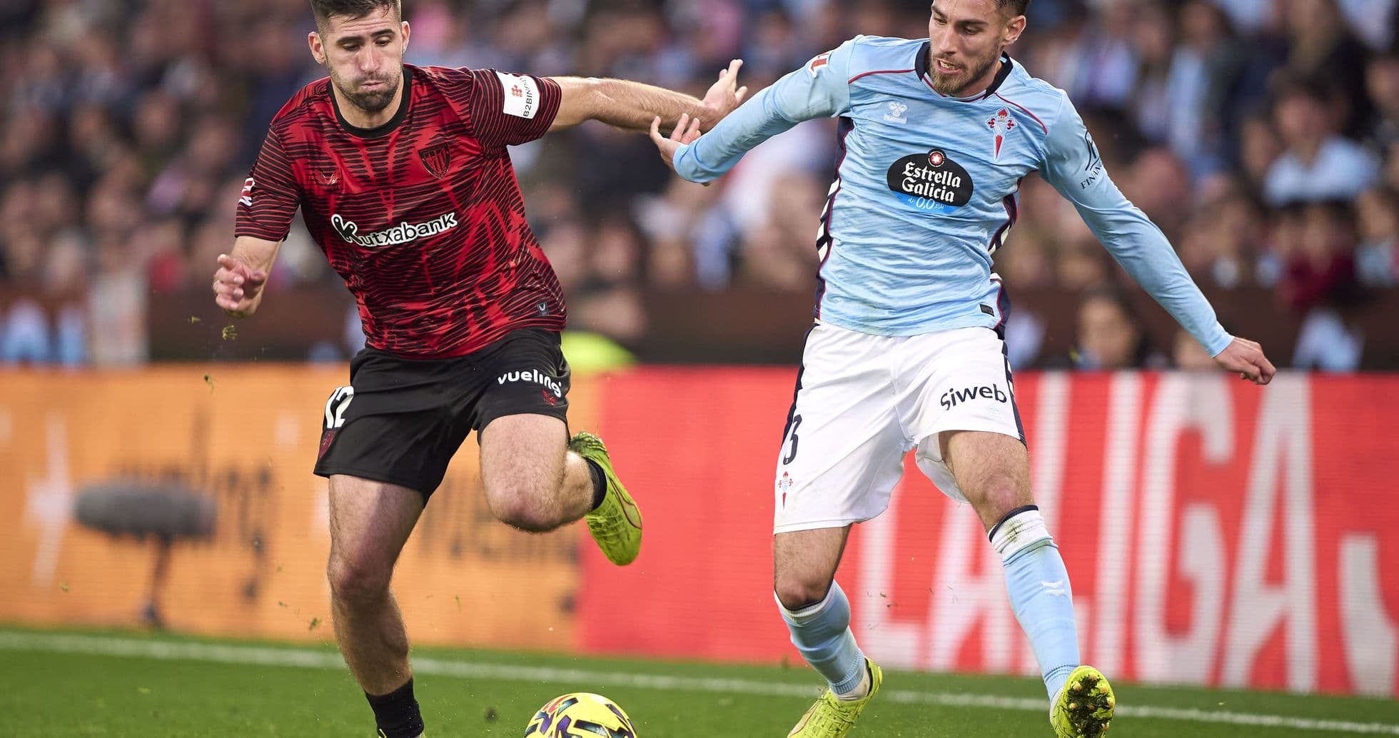 Athletic Club player challenging Celta Vigo opponent Athletic Club player challenging Celta Vigo opponent