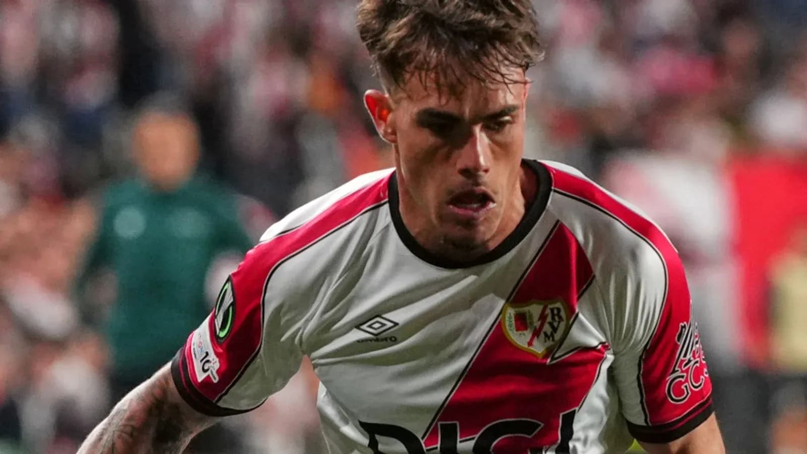 Player in Rayo Vallecano kit running on field Player in Rayo Vallecano kit running on field