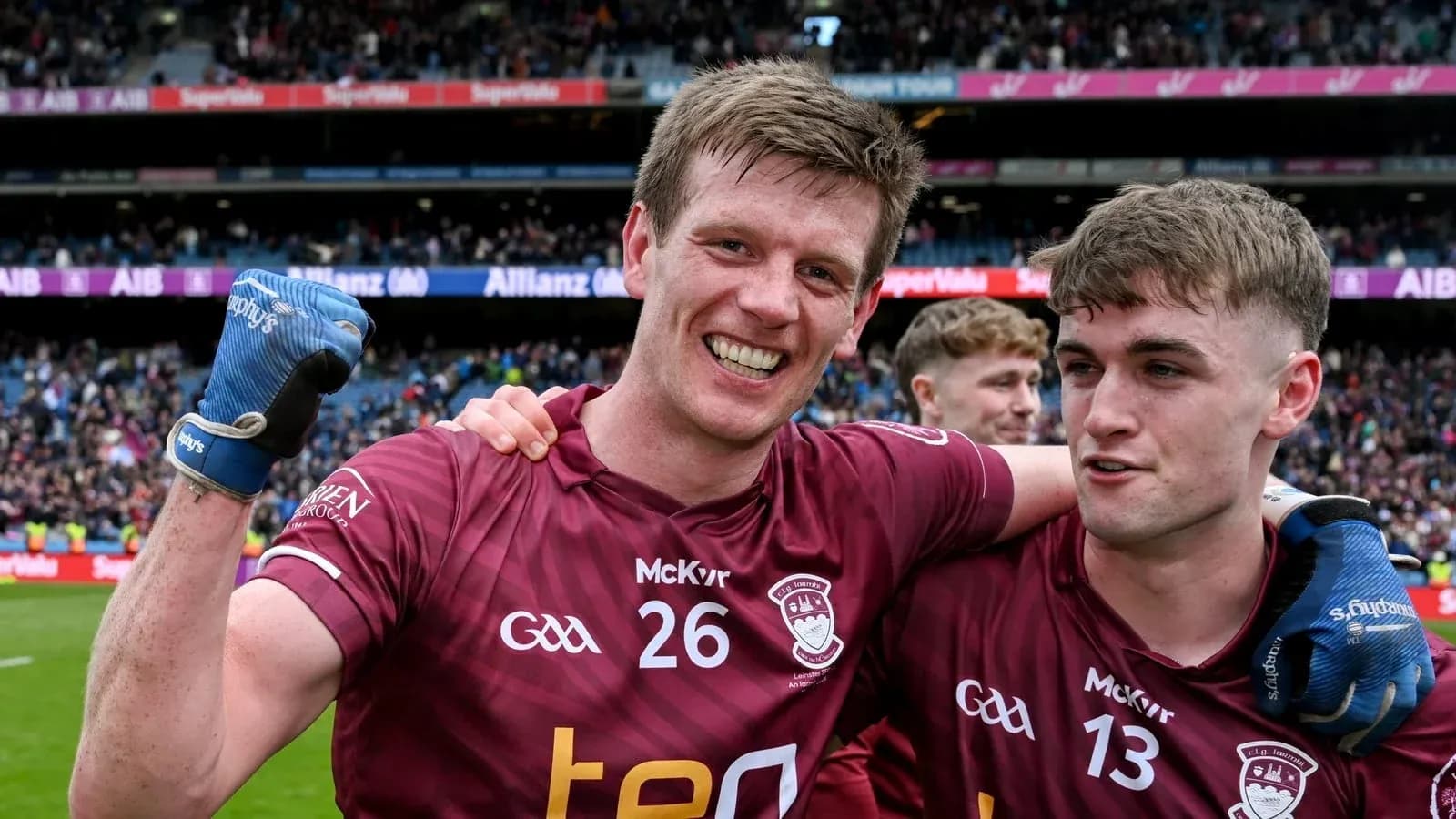 Two players celebrating in maroon jerseys after match Two players celebrating in maroon jerseys after match