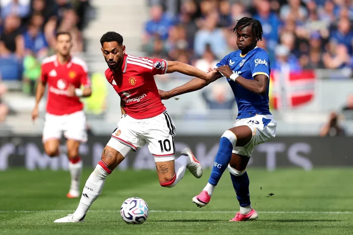 Manchester United player dribbling past Everton defender Manchester United player dribbling past Everton defender