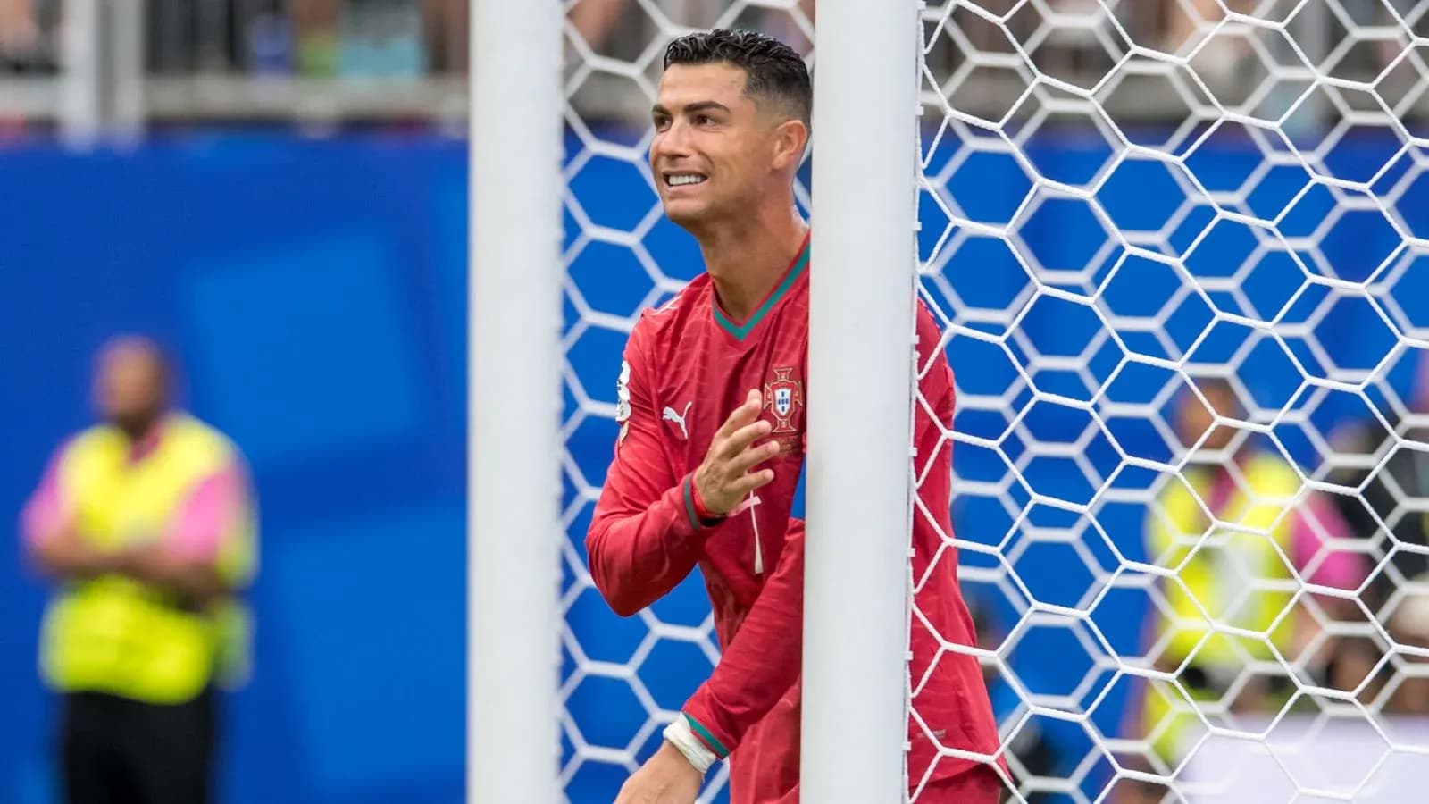 Player in red jersey celebrating near goalpost Player in red jersey celebrating near goalpost