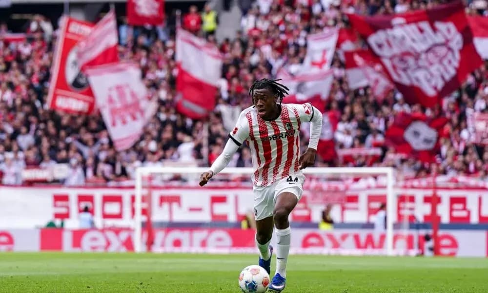 Player dribbling the ball in front of cheering fans Player dribbling the ball in front of cheering fans