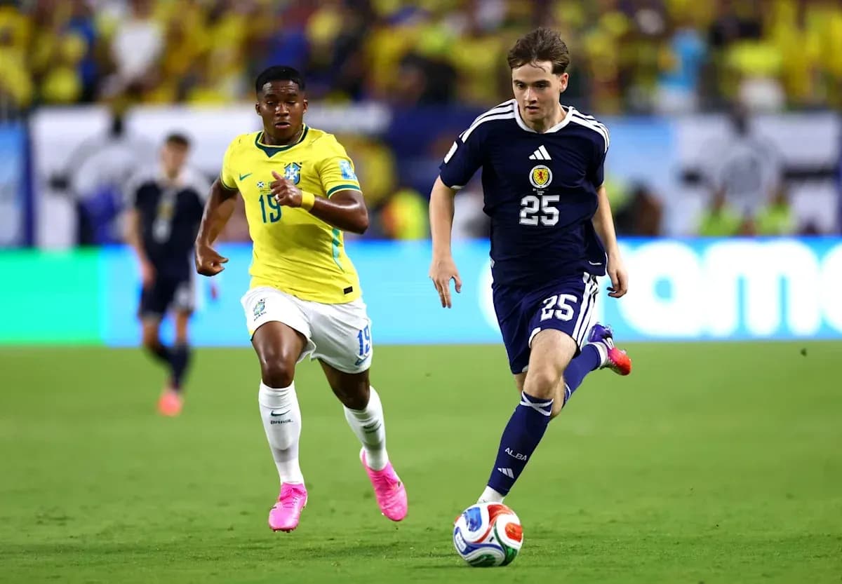 Player from Scotland dribbling the ball, Brazilian defender pursuing Player from Scotland dribbling the ball, Brazilian defender pursuing