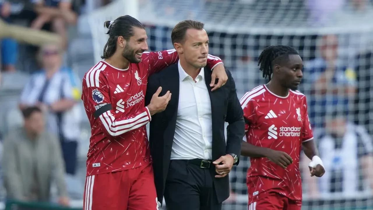 Liverpool players celebrating with their manager on pitch Liverpool players celebrating with their manager on pitch