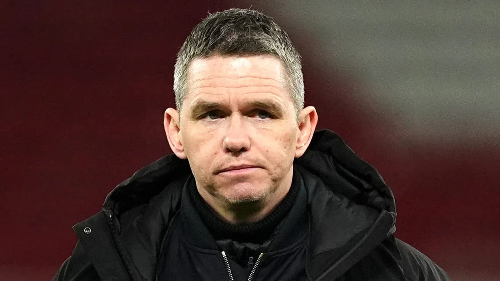Football manager in a black jacket on the field Football manager in a black jacket on the field