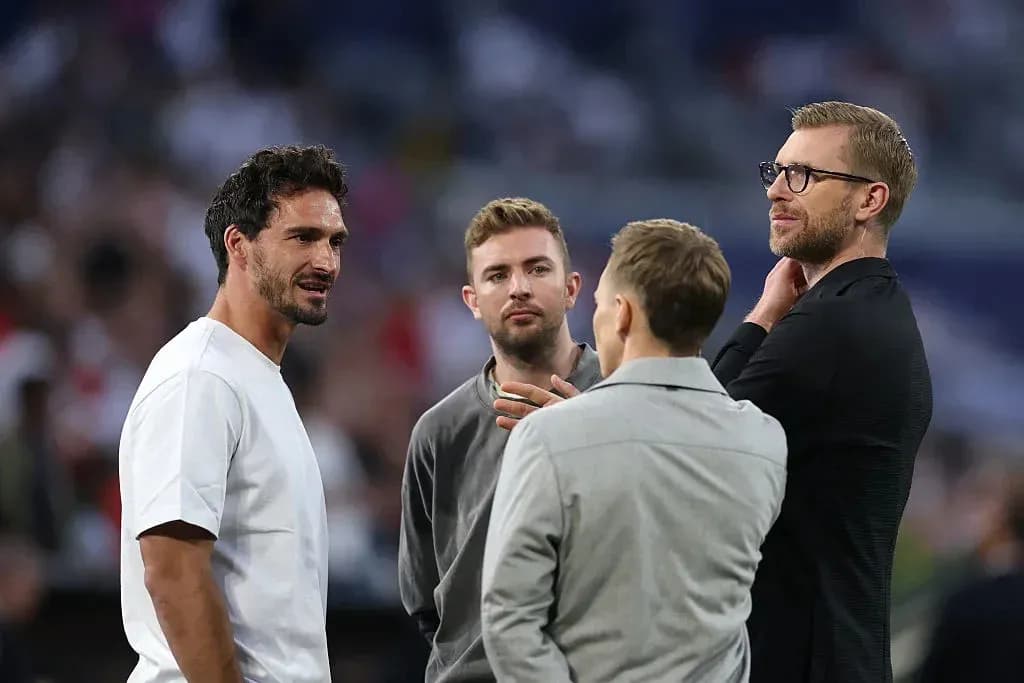 Four men conversing on the sidelines of a match Four men conversing on the sidelines of a match