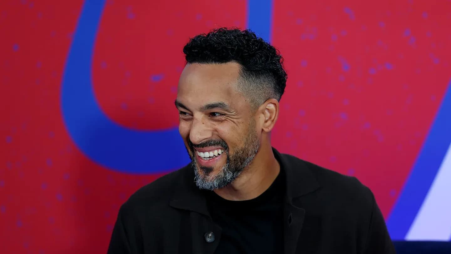 Man smiling during a media event backdrop Man smiling during a media event backdrop