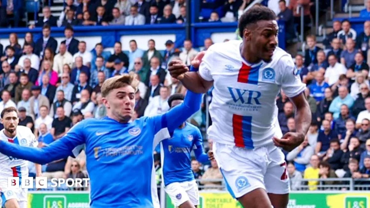 Player in blue jersey challenging player in white jersey Player in blue jersey challenging player in white jersey
