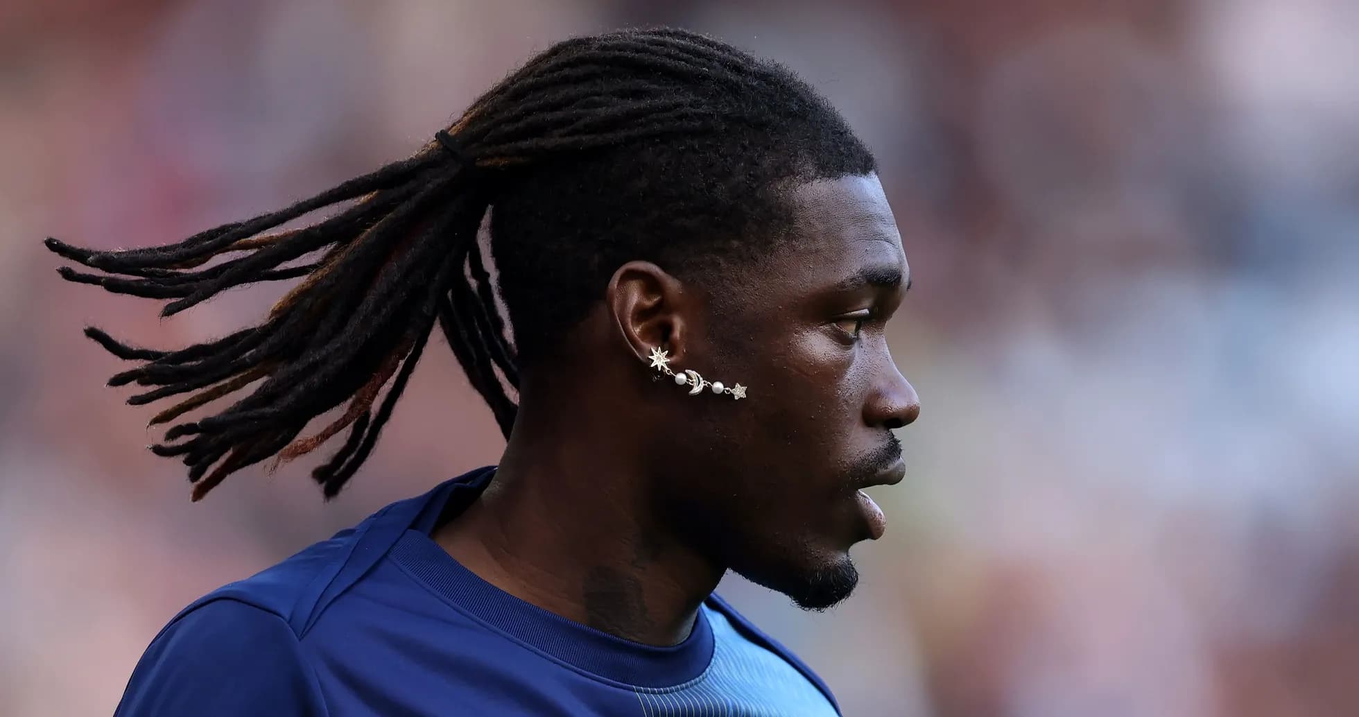 Player with long hair and unique earrings on field Player with long hair and unique earrings on field