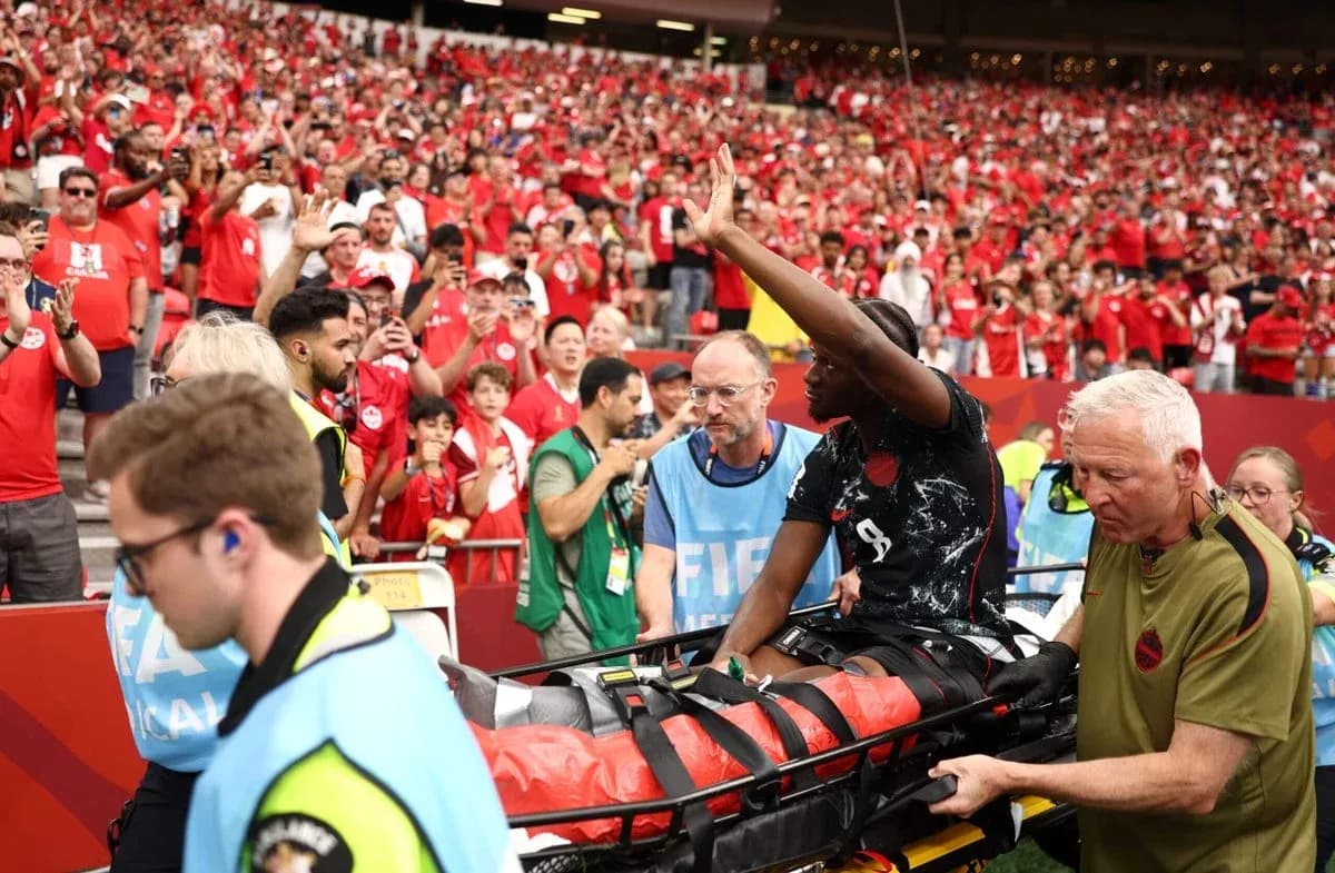 Player being carried on stretcher amid cheering crowd Player being carried on stretcher amid cheering crowd