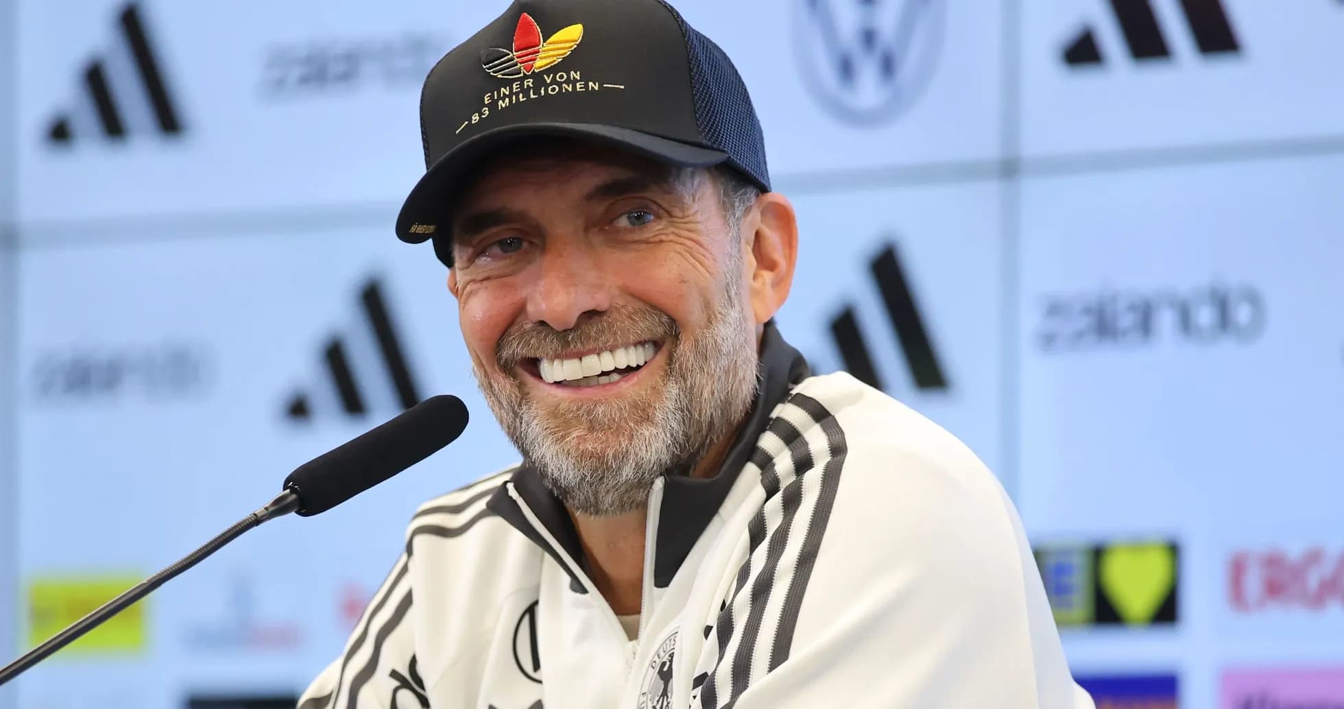 Coach smiling at press conference with microphone Coach smiling at press conference with microphone