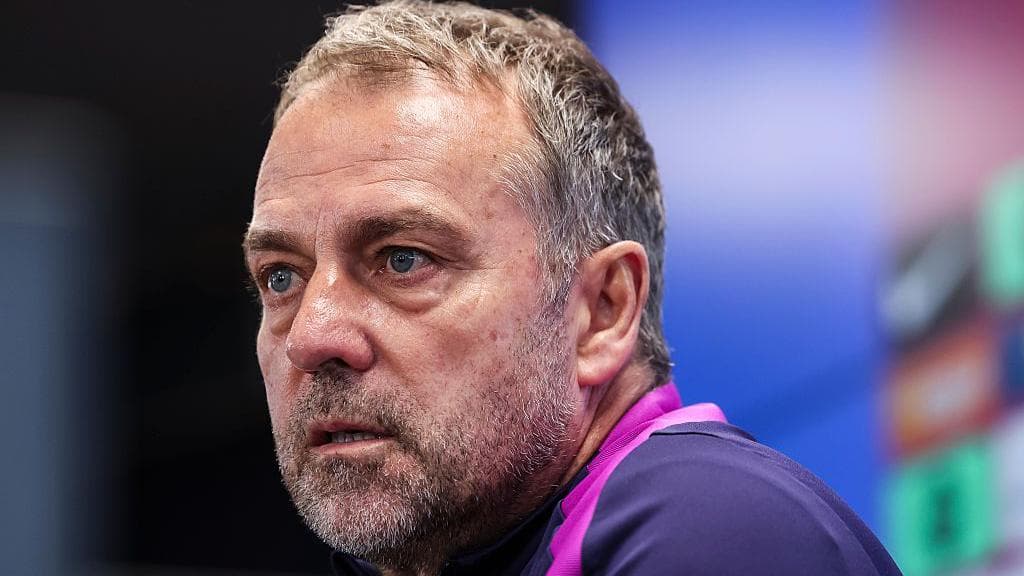 Coach speaking at press conference with serious expression Coach speaking at press conference with serious expression